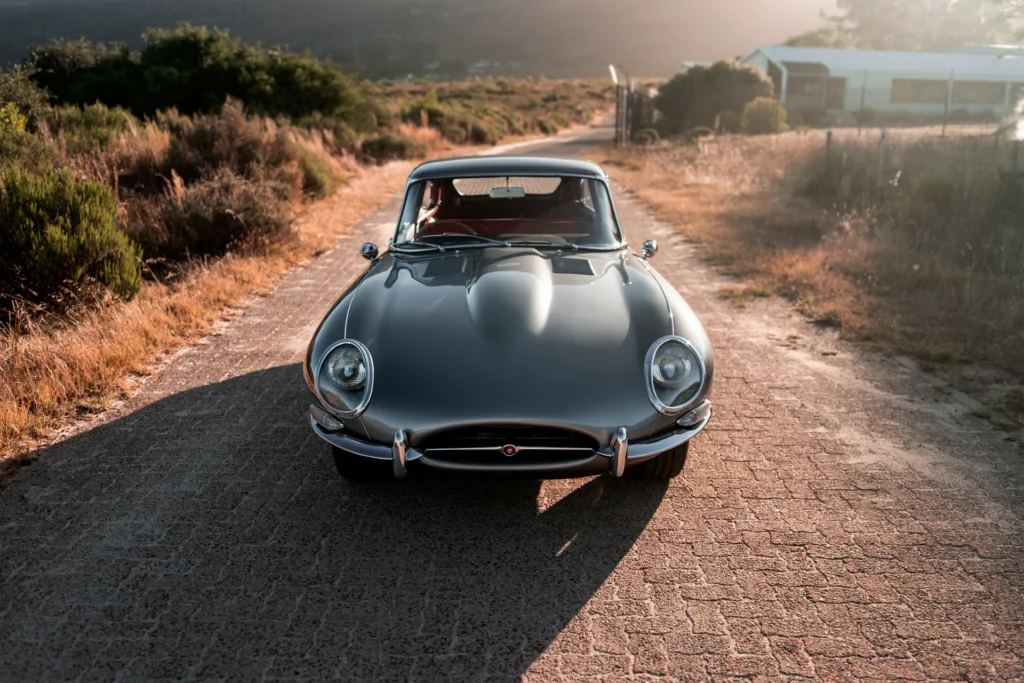 Jaguar E-Type su una strada di campagna - fotografia editoriale di Jason Clifton, Unsplash
