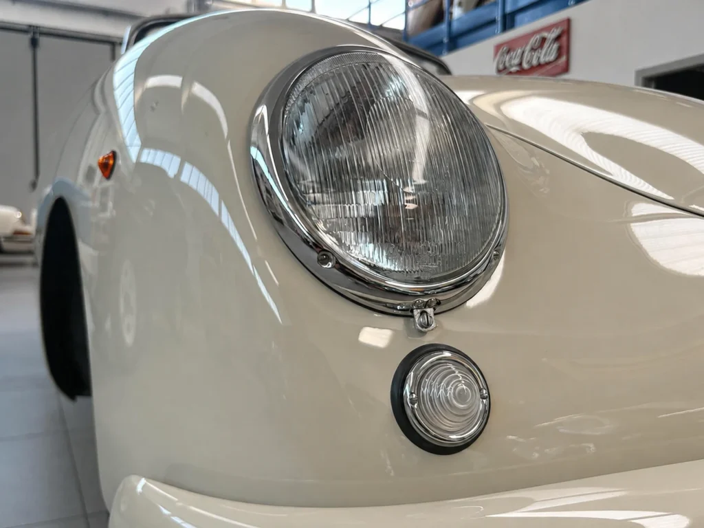 Faro anteriore e indicatore sulla carrozzeria avorio della Porsche 356 Pre-A Cabriolet del 1953 in officina SC Classic